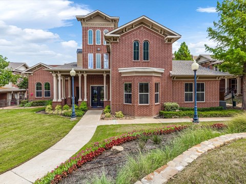 the front of a brick house with a sidewalk in front of it